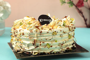 A deliciously crafted Kabhi B cake, topped with whipped cream, nuts, and delicate garnishes.