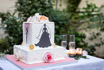 A stunning Kabhi B wedding cake featuring elegant white icing, intricate floral details, and a silhouette of a bride, making it perfect for a romantic celebration.